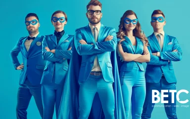 Équipe de professionnels en marketing digital de BETC Communication portant des costumes bleus et des masques de super-héros.