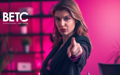 Amélioration SEO avec BETC, femme pointant du doigt, arrière-plan rose