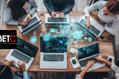 Équipe de travail collaborant sur des ordinateurs portables dans une agence digitale BETC.