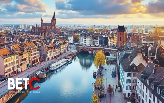 Vue panoramique de Strasbourg avec le logo de BETC Communication, une agence digitale et de publicité située en Alsace.