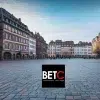 Place centrale du Grand Est avec des bâtiments historiques et logo de BETC Communication, agence digitale.