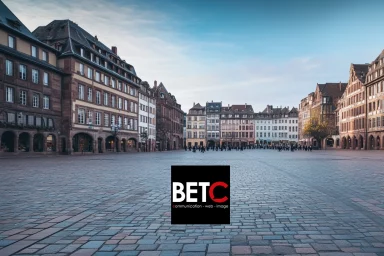 Place centrale du Grand Est avec des bâtiments historiques et logo de BETC Communication, agence digitale.