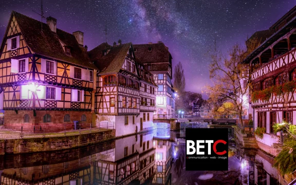 Vue nocturne de Strasbourg avec maisons à colombages et ciel étoilé, illustrant l'importance du SEO local pour les entreprises.
