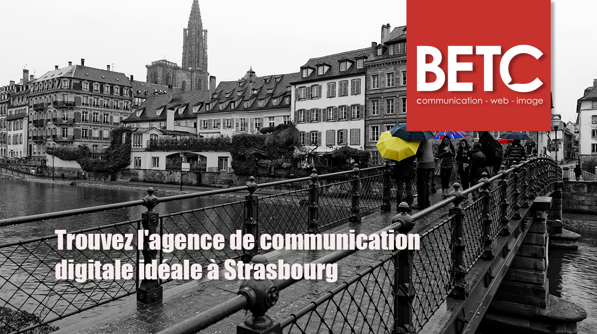 Vue de Strasbourg avec la cathédrale en arrière-plan, un pont animé et des passants tenant des parapluies colorés, illustrant l'importance d'une agence de communication digitale locale comme BETC.